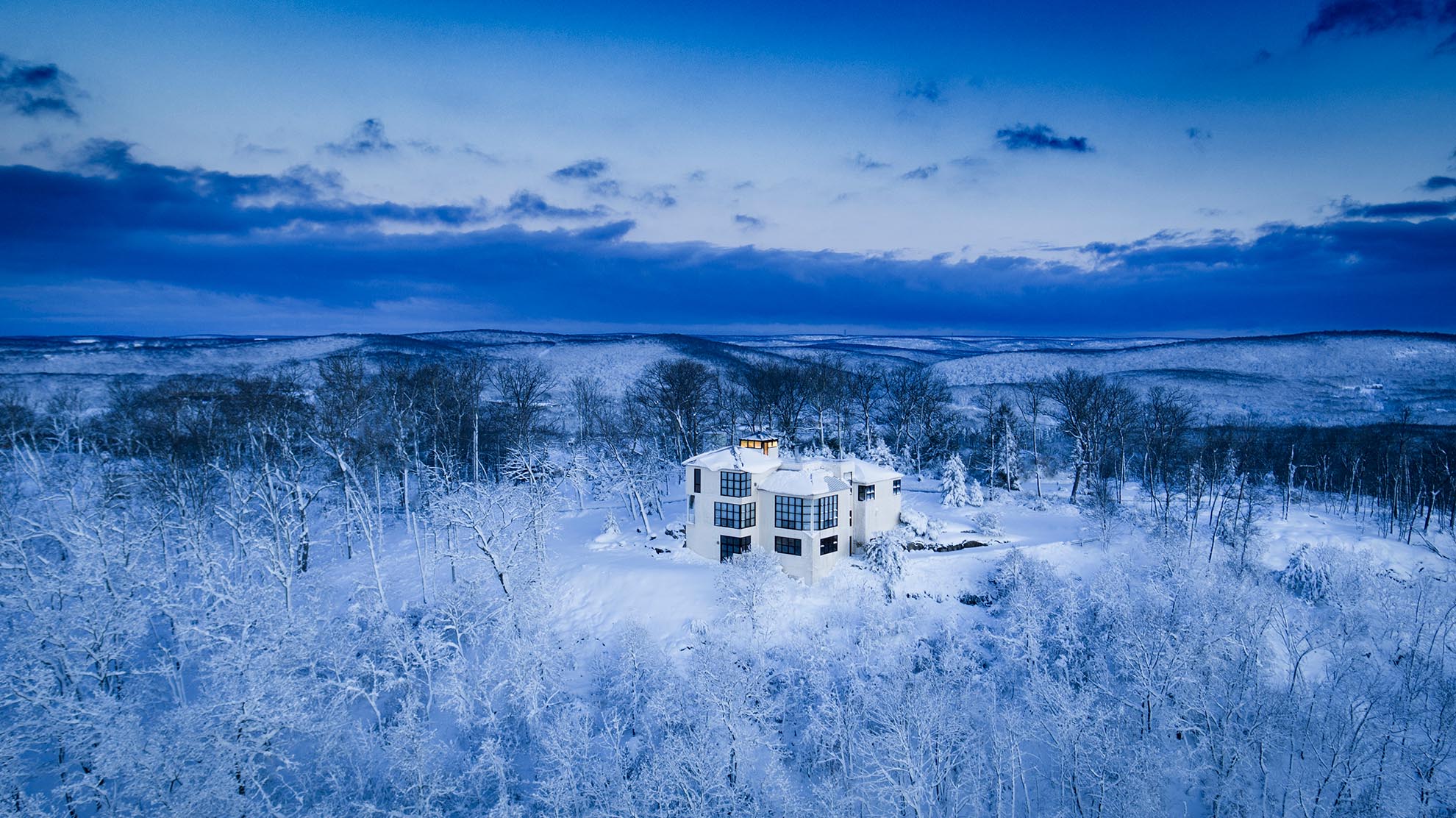 Drone Photograph of white Modern Home on Mountain Top after snow storm in NJ