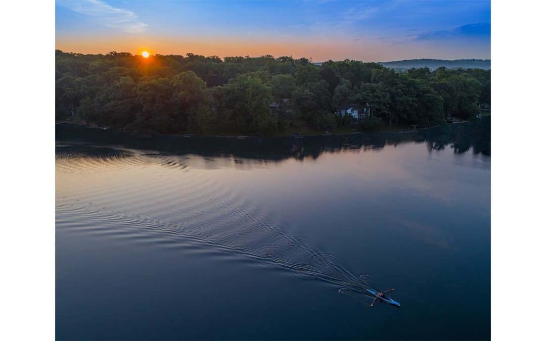 Drone photograph of a man in a single rowing scull during sunrise over Cedar Lake New Jersey