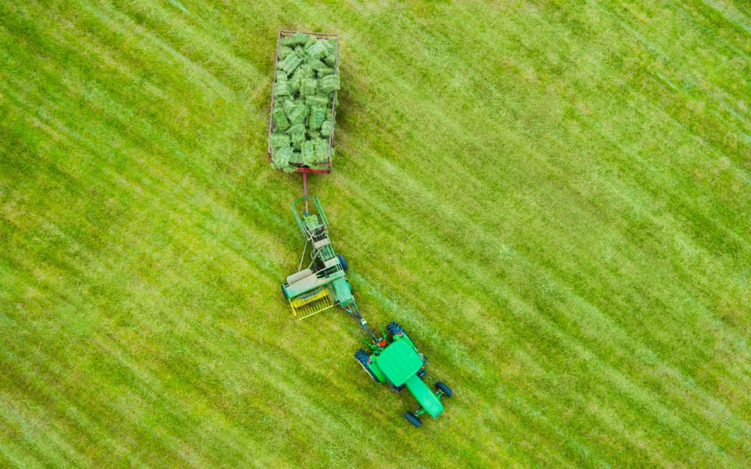 Drone Photograph of birds eye view of farm tractor with hay bails in New Jersey