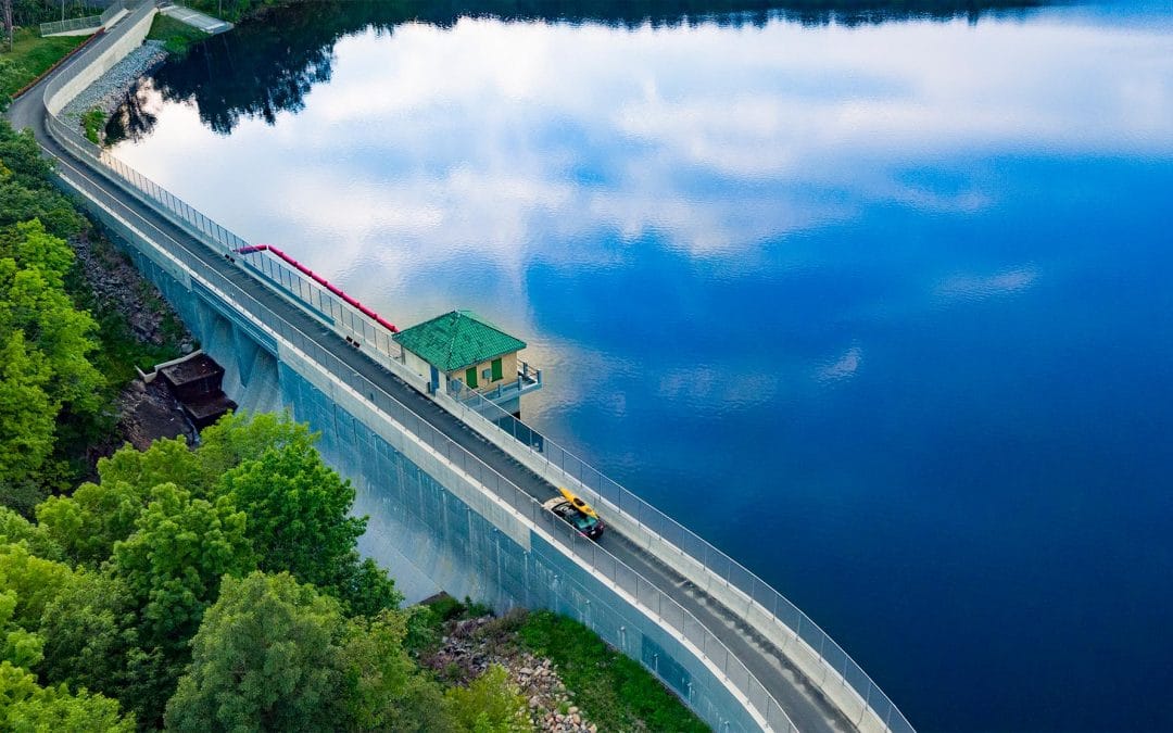 Drone Photograph of car with yellow kayak on roof crossing the Split Rock Dam