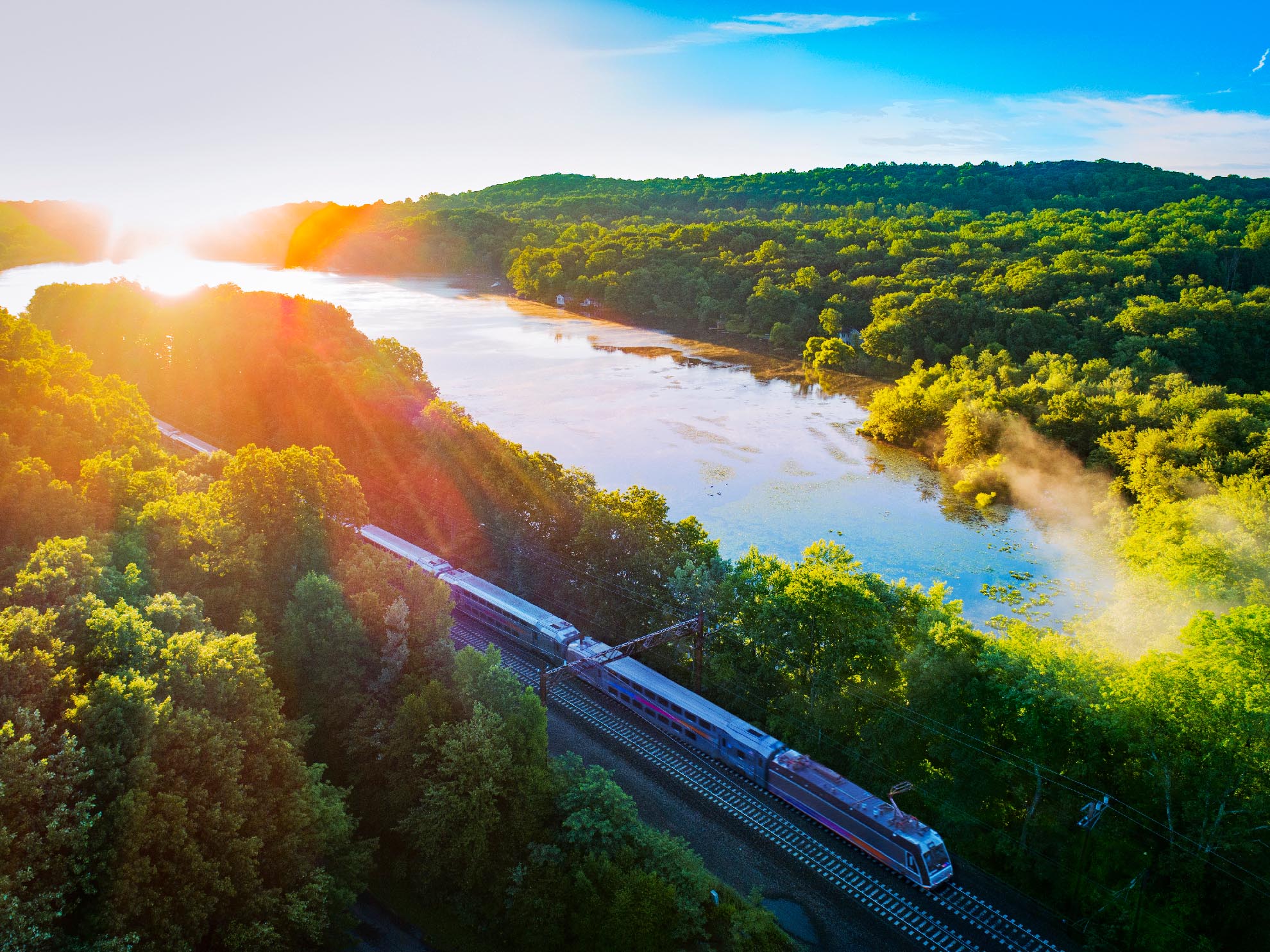 Photograph of Lake Estling NJ with commuter train going by at sunrise taken with a drone