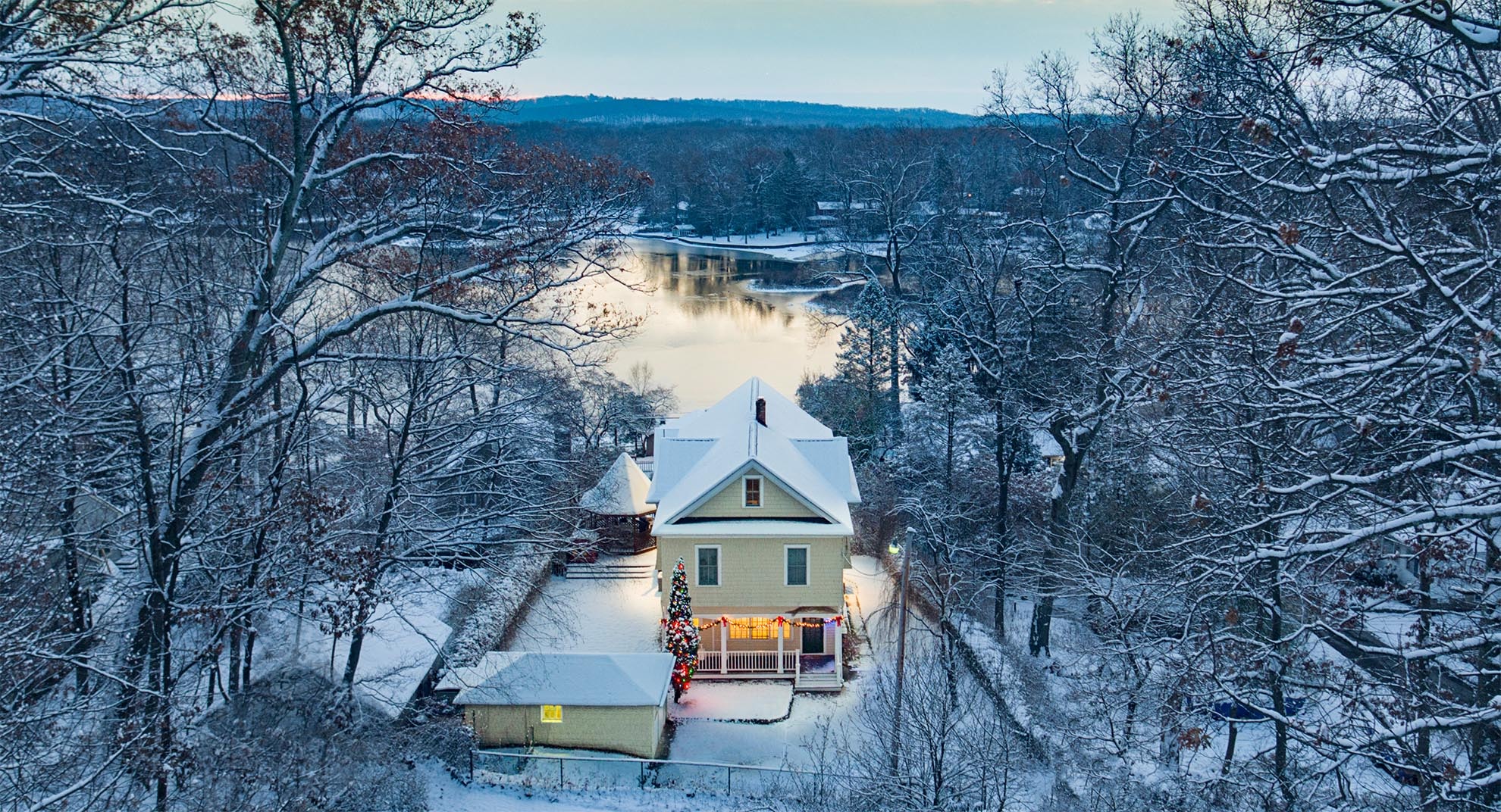Drone Photograph of Lake Home with Christmas Decorations after snow fall