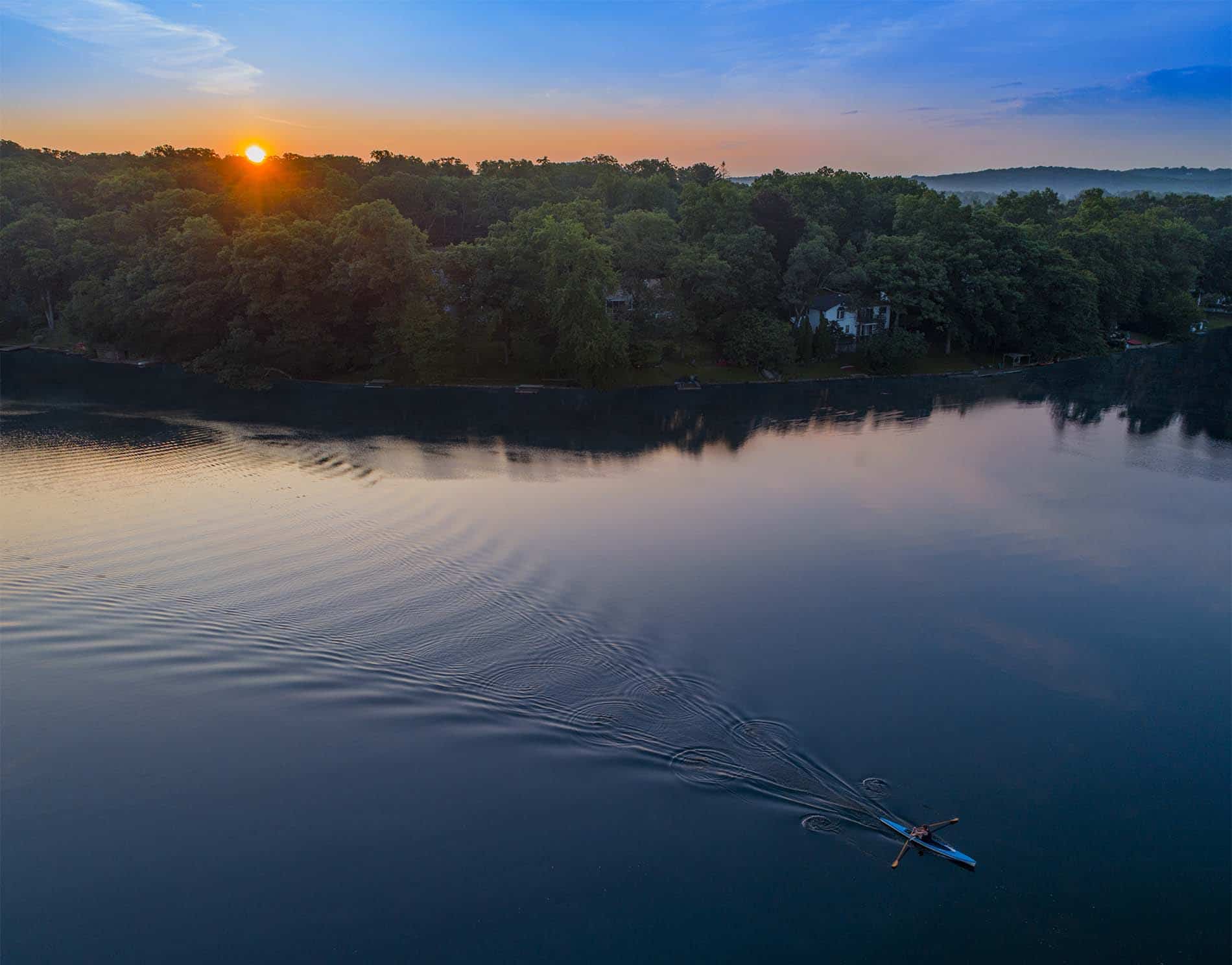 Drone Photograph of man rowing in a rowing scull at sunrise on Cedar Lake New Jersey
