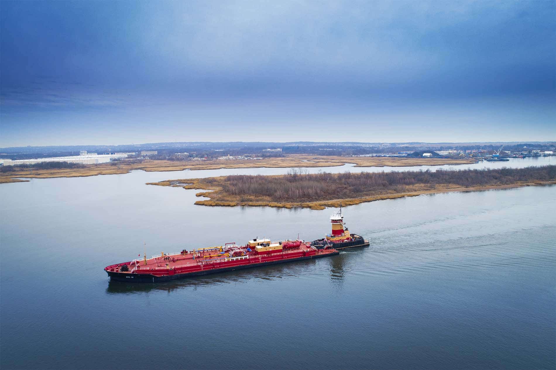 Drone Photograph of Red Barge being pushed by a Tug Boat going up the Arthur Kill River