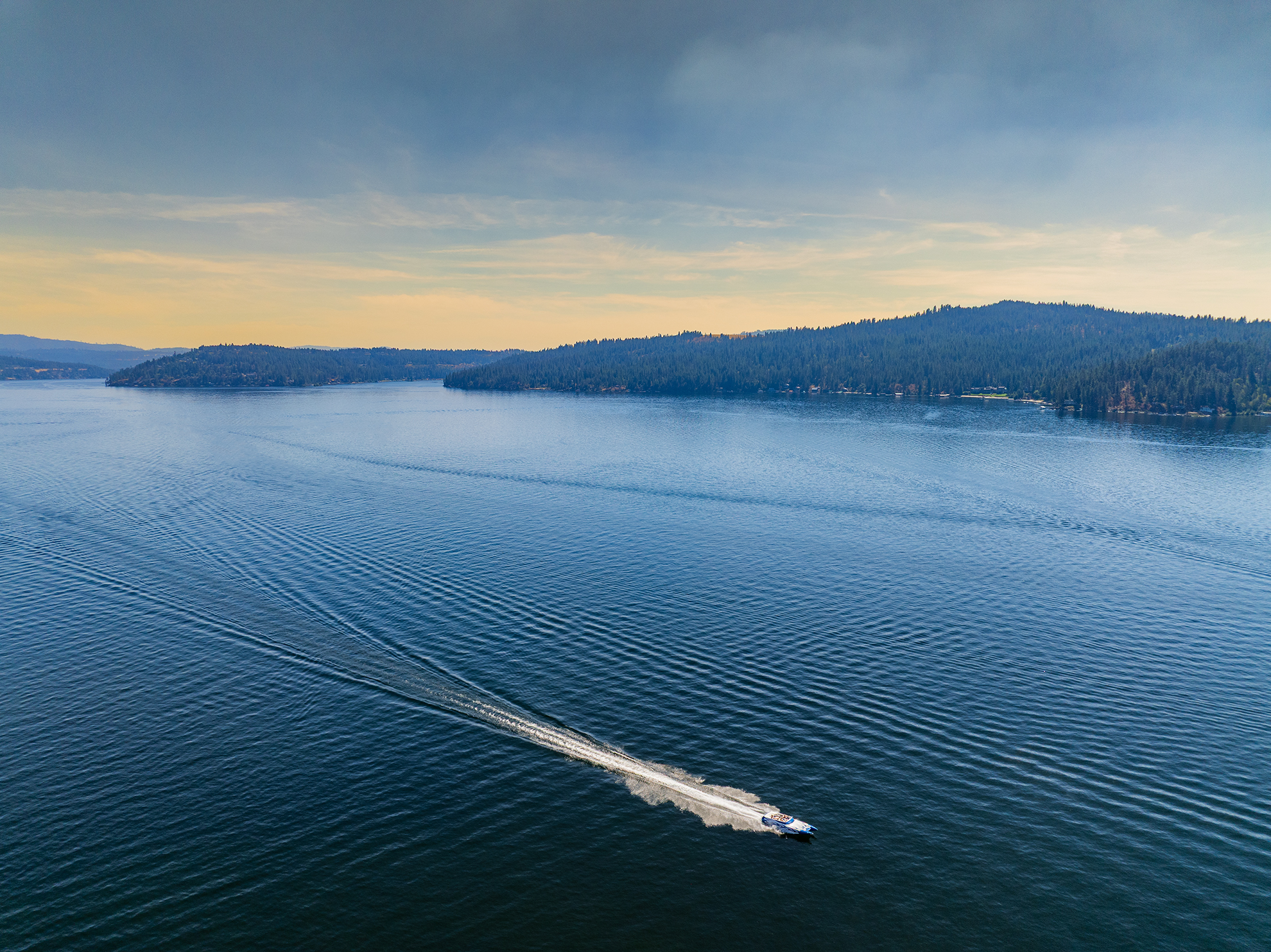 Drone photograph of a speed boat cruising on Lake Couer d' Alene